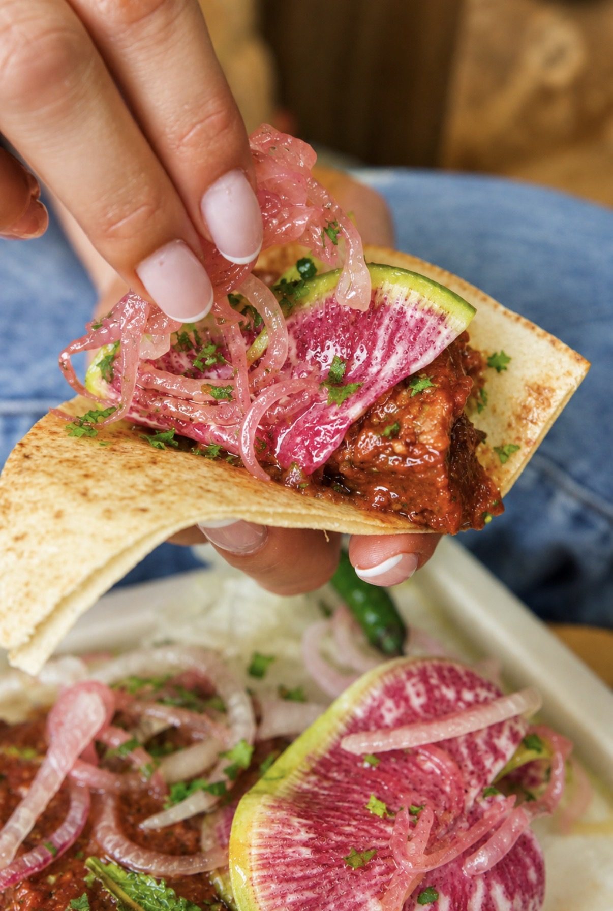 Pita filled with braised meat, pickled onion and watermelon radish at Layali Miami